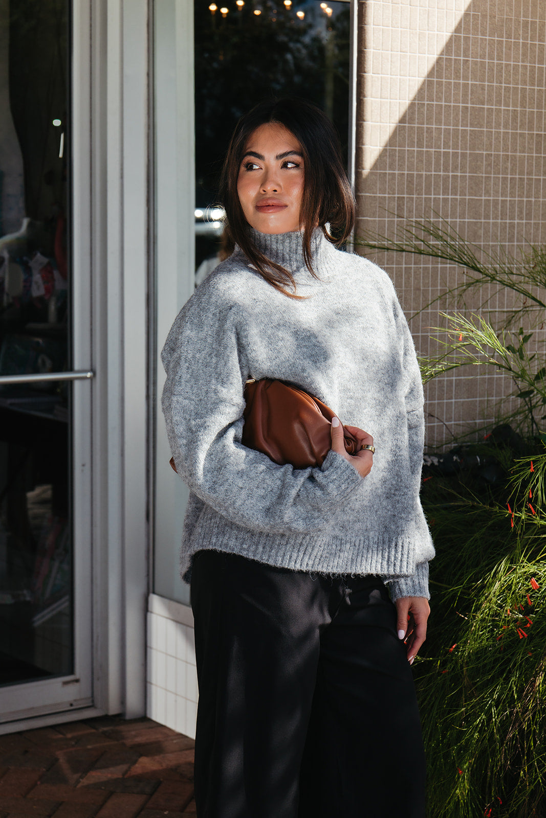 Woman wearing the Audette Sweater, an oversized charcoal heather grey ribbed turtleneck sweater