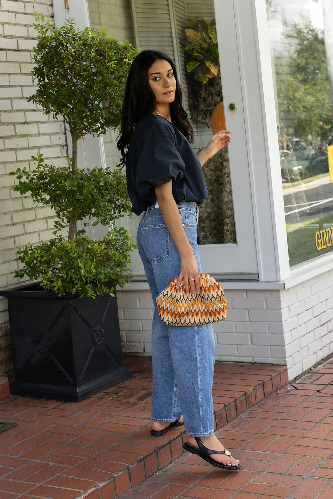 Woman wearing the Cordelia Bubble Hem Top, a navy cropped puff sleeve top with a tie front