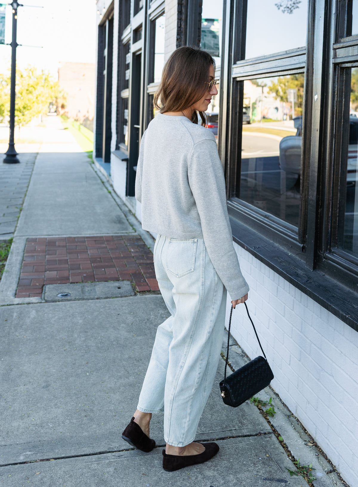 Woman wearing the Cova Cardigan, a grey cropped cotton-wool crewneck cardigan