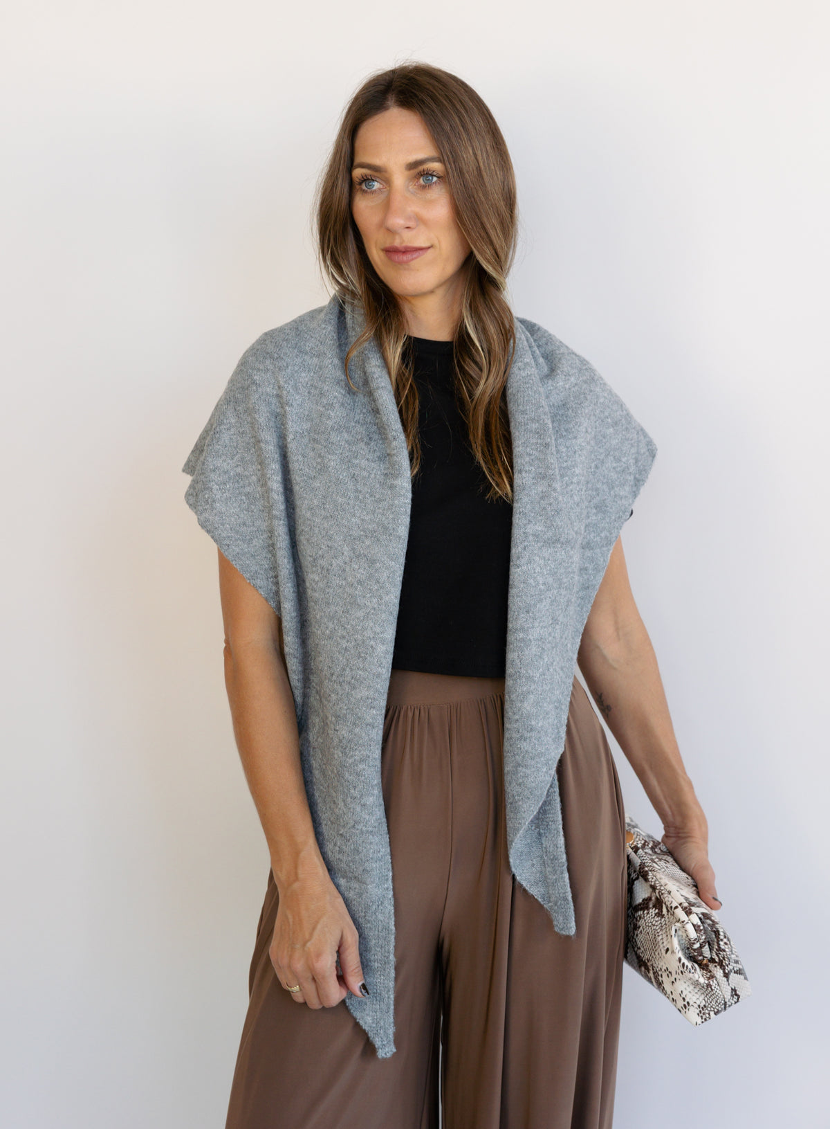 Woman wearing the Wrenley Warm Shawl Scarf in Grey, a heathered grey knit triangle shawl