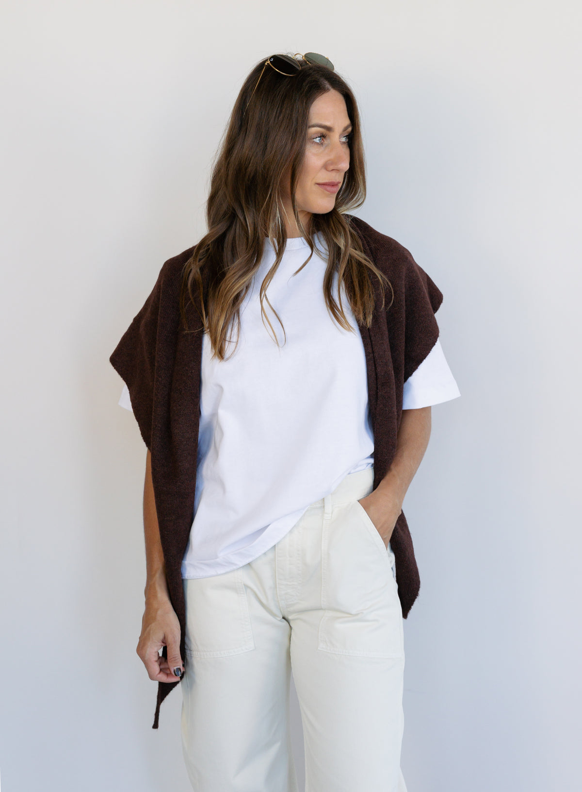 Woman wearing the Wrenley Warm Shawl Scarf in Brown, a chocolate brown knit triangle shawl