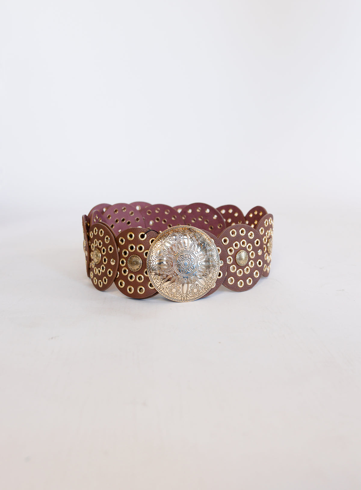 Greta Wide Western Belt in Cognac, a wide cognac disc belt with silver grommets and a concho buckle