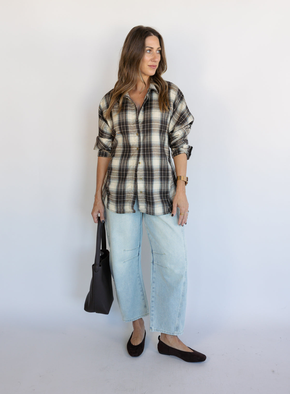 Woman wearing the Heartloom Bobbie Shirt, a black, cream and grey plaid oversized button-down