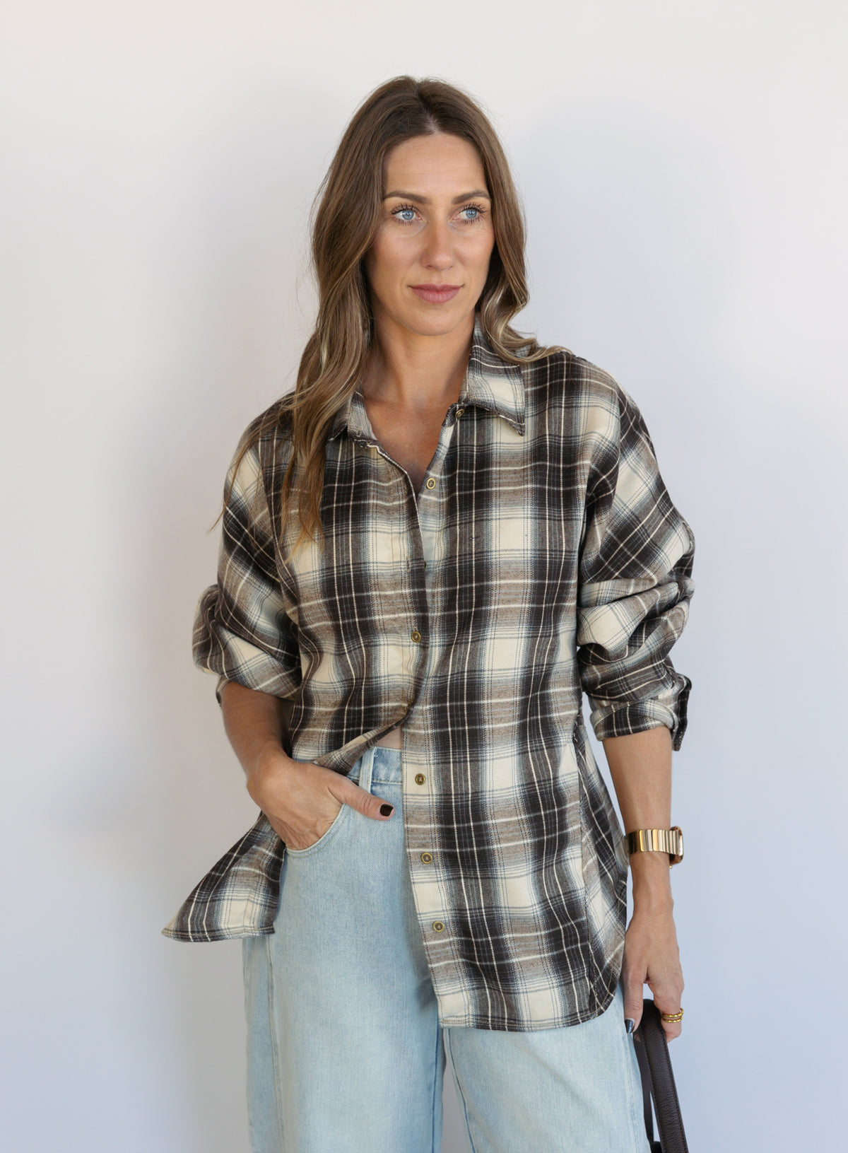 Woman wearing the Heartloom Bobbie Shirt, a black, cream and grey plaid oversized button-down