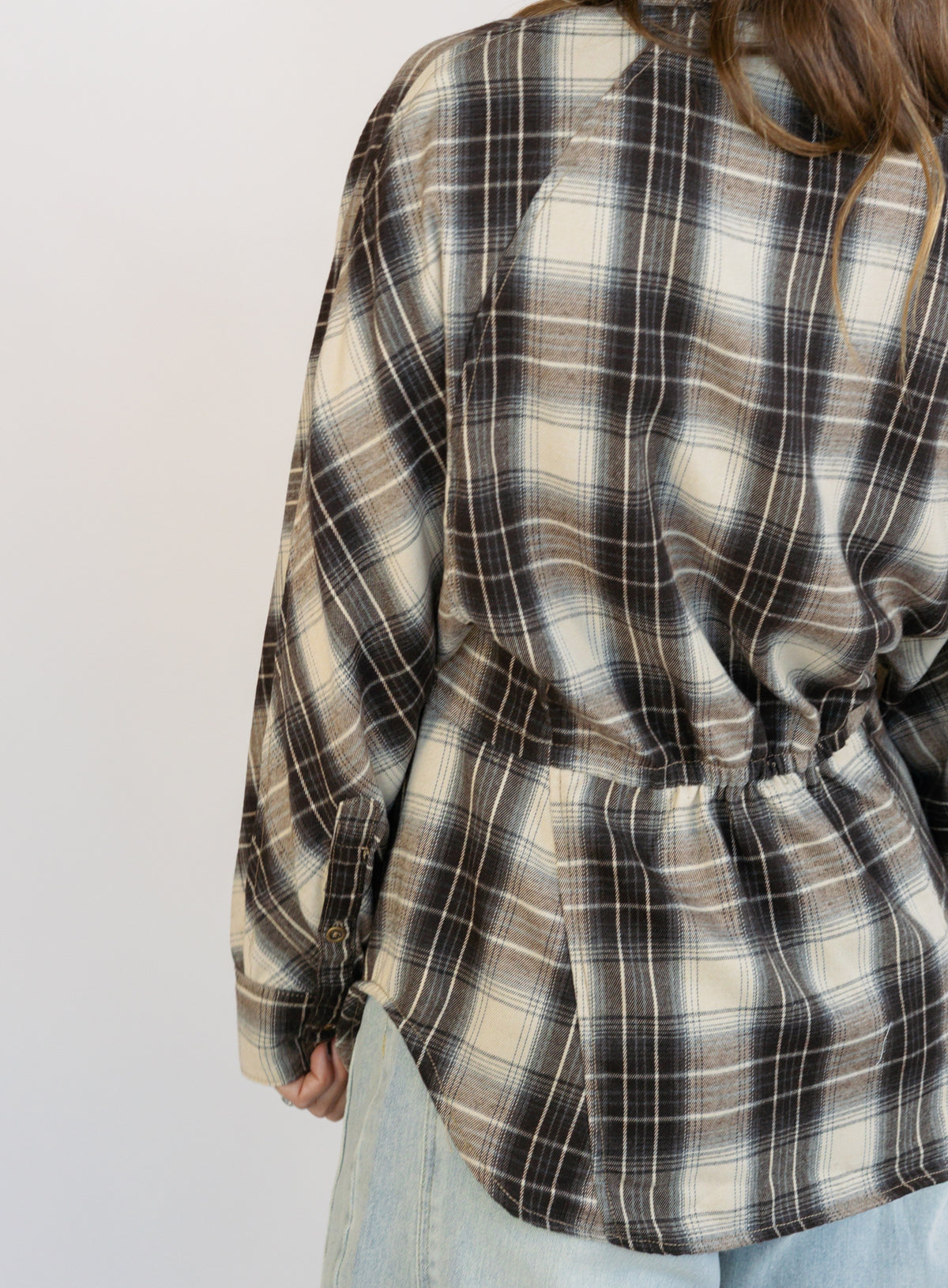 Woman wearing the Heartloom Bobbie Shirt, a black, cream and grey plaid oversized button-down