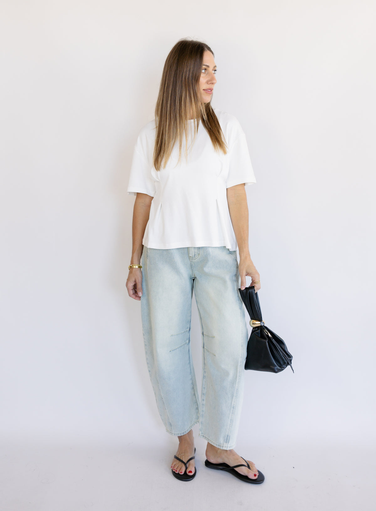 Woman wearing the Lakelyn Cinched Top, a white structured knit crewneck tee cinched at the waist