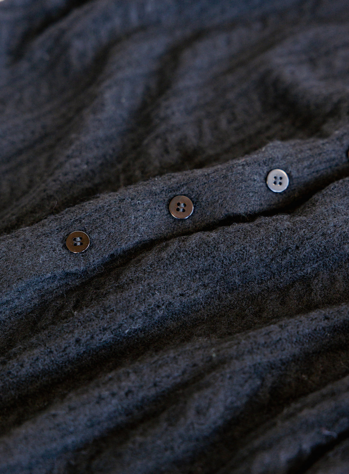 Woman wearing the Z Supply Medina Pointelle Cardigan, a black cable pointelle knit button-front cardigan