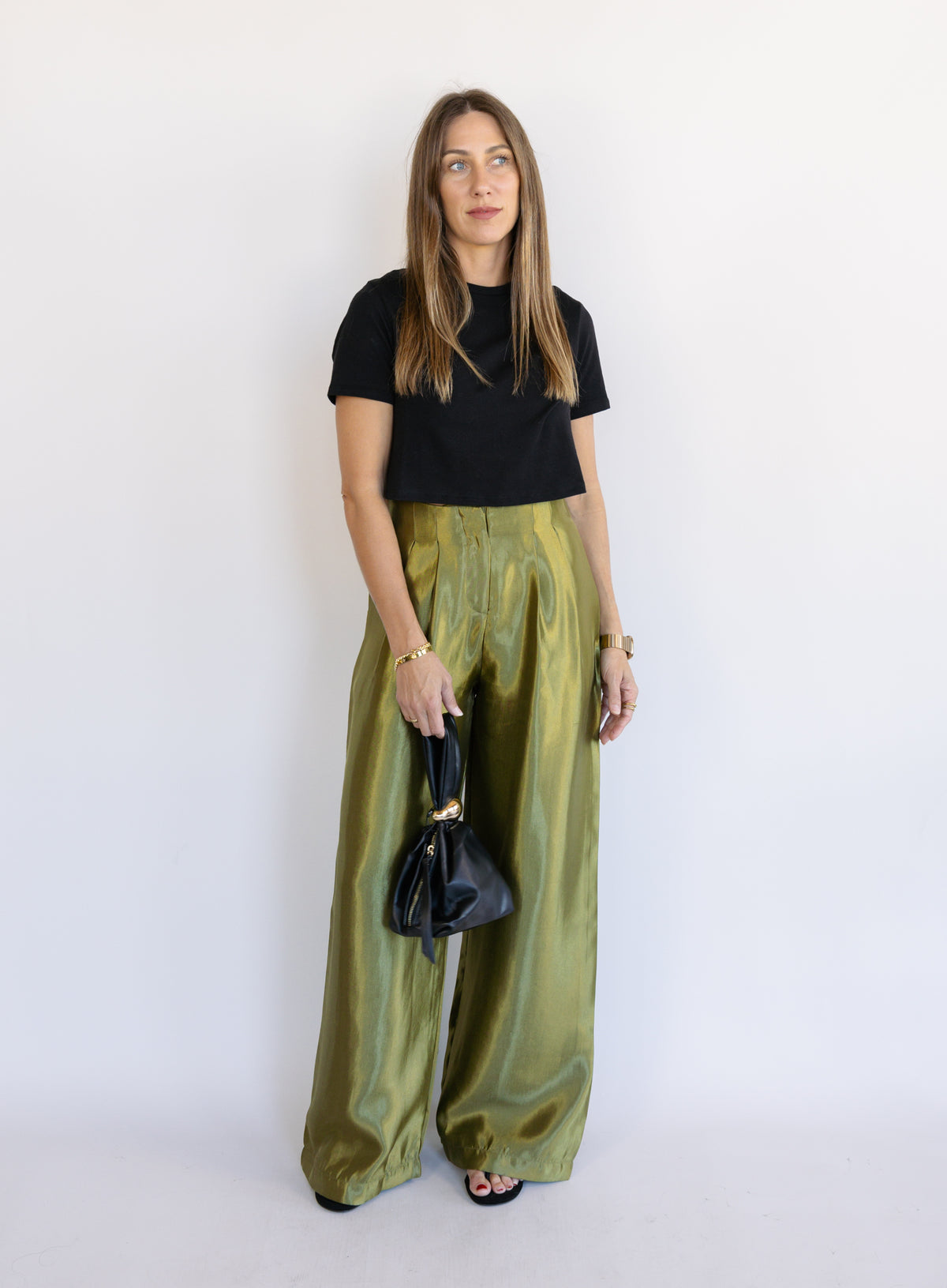 Woman wearing the Sophia Pleated Pants, olive high-rise wide-leg pleated pants
