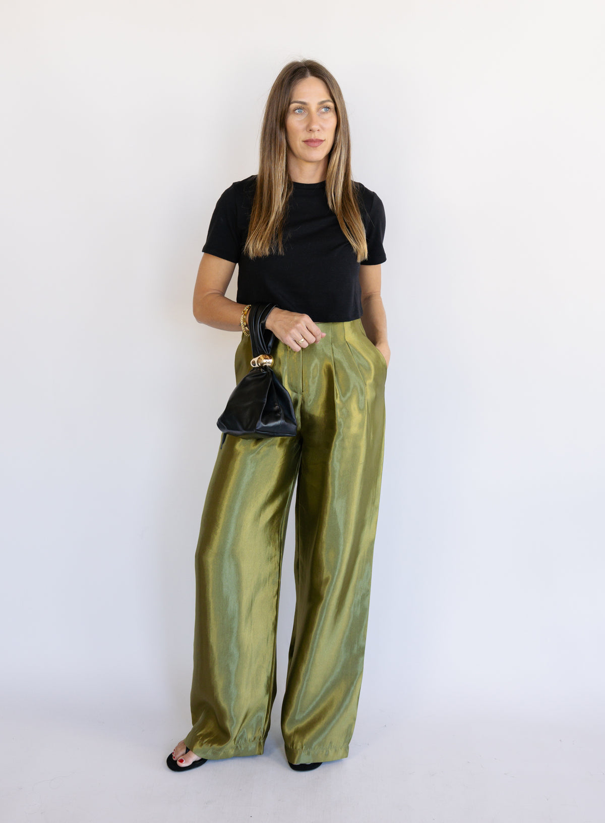 Woman wearing the Sophia Pleated Pants, olive high-rise wide-leg pleated pants
