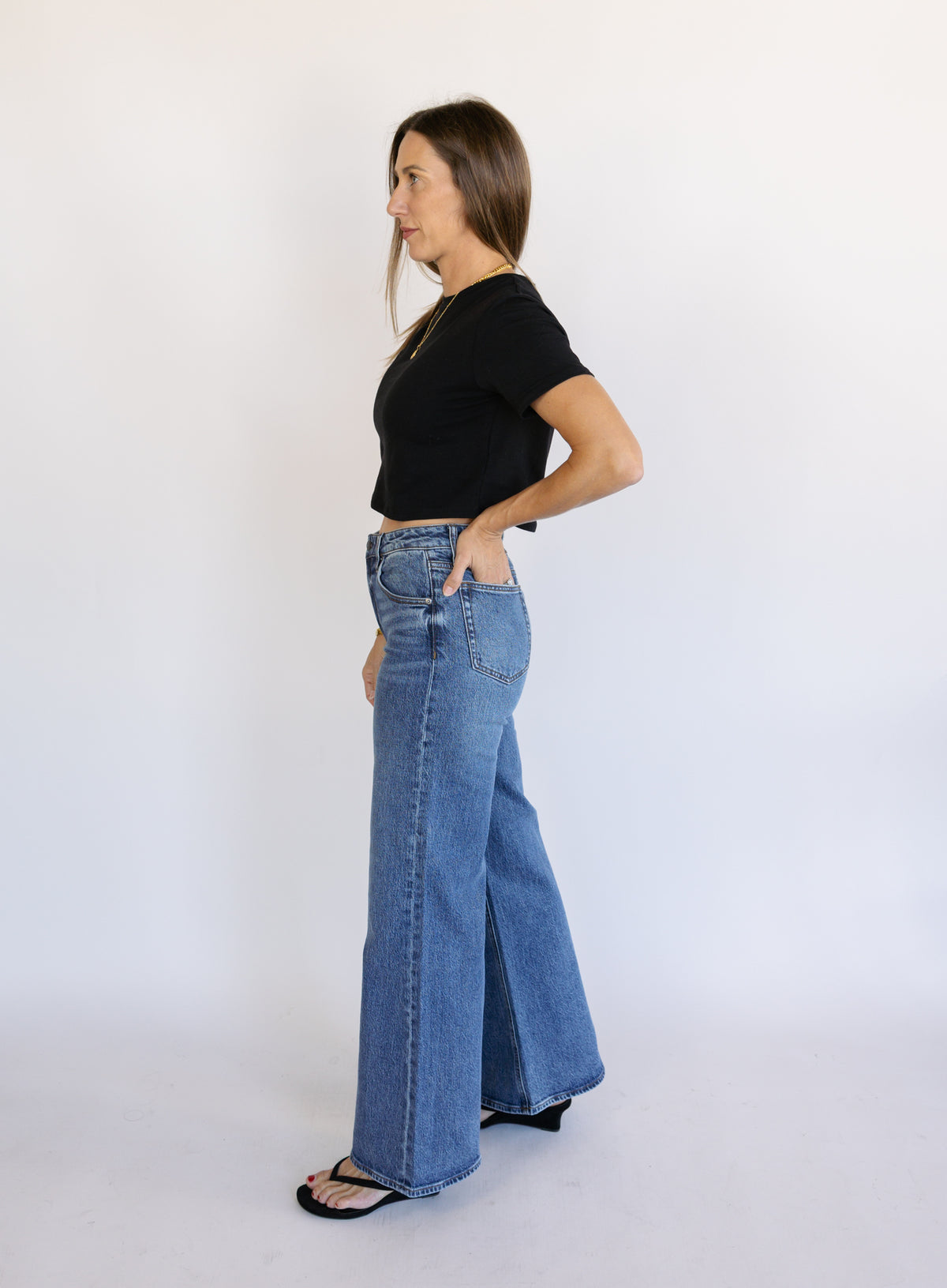 Woman wearing Z Supply The Stunner Mid Rise Wide Leg jeans in Element, a vintage medium wash