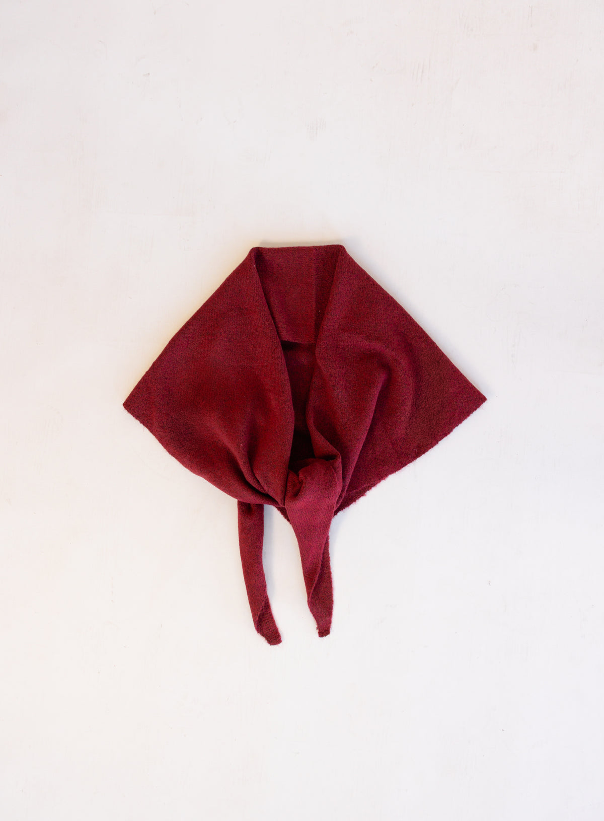 Woman wearing the Wrenley Warm Shawl Scarf in Red, a wine red knit triangle shawl