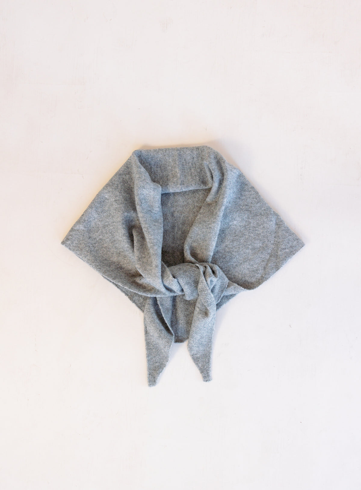 Woman wearing the Wrenley Warm Shawl Scarf in Grey, a heathered grey knit triangle shawl