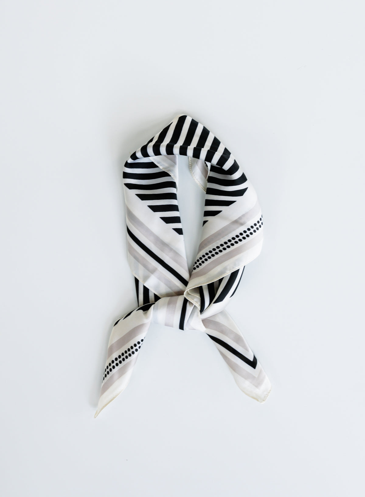 Woman wearing the Tovi Scarf, a black twill square scarf