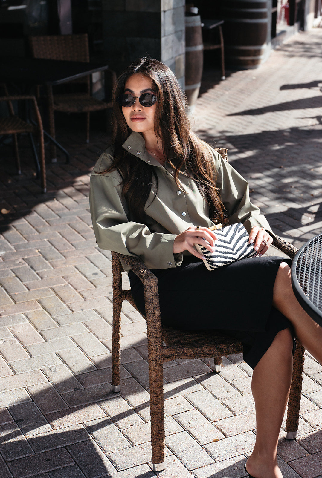 Woman wearing the Mesa Bermuda Shorts, black trouser-style shorts that fall just below the knee
