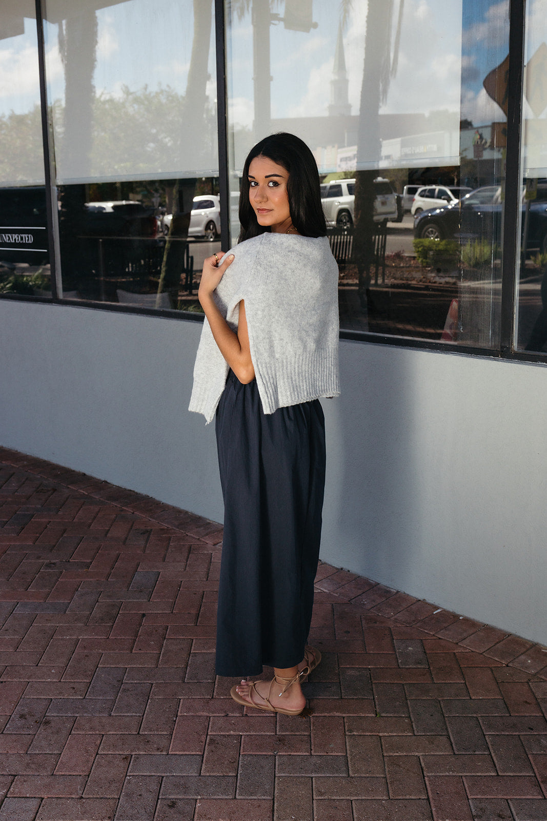 Woman wearing the Cordelia Skirt, a navy maxi skirt with an elastic waist and pockets