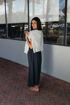 Woman wearing the Cordelia Skirt, a navy maxi skirt with an elastic waist and pockets