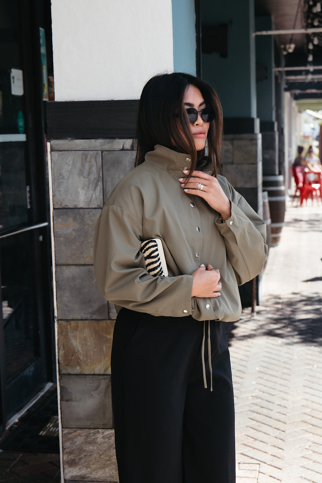 Woman wearing the Mesa Bermuda Shorts, black trouser-style shorts that fall just below the knee