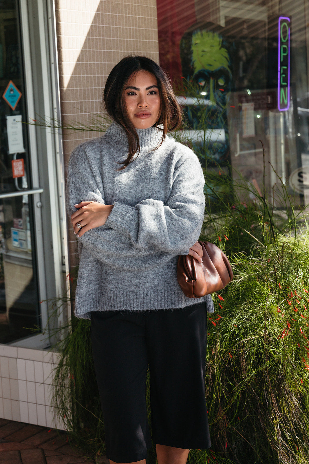 Woman wearing the Audette Sweater, an oversized charcoal heather grey ribbed turtleneck sweater