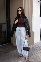 Woman wearing the ASTR The Label Kyra Sheer Mesh Mock Neck Top, a fitted wine top with floral lace detailing