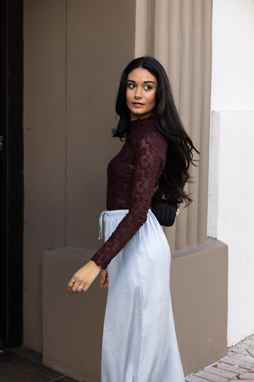 Woman wearing the ASTR The Label Kyra Sheer Mesh Mock Neck Top, a fitted wine top with floral lace detailing