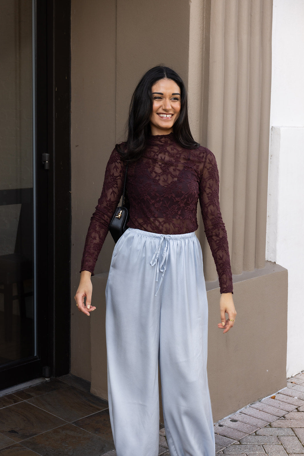 Woman wearing the ASTR The Label Kyra Sheer Mesh Mock Neck Top, a fitted wine top with floral lace detailing