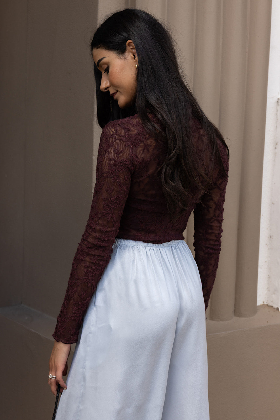 Woman wearing the ASTR The Label Kyra Sheer Mesh Mock Neck Top, a fitted wine top with floral lace detailing