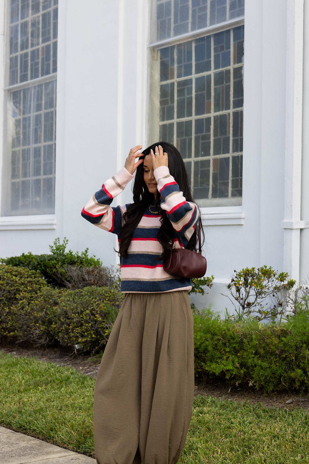 Woman wearing the Carlyle Everyday Sweater, a relaxed navy, cream and blush striped crewneck sweater