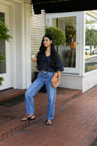 Woman wearing the Cordelia Bubble Hem Top, a navy cropped puff sleeve top with a tie front