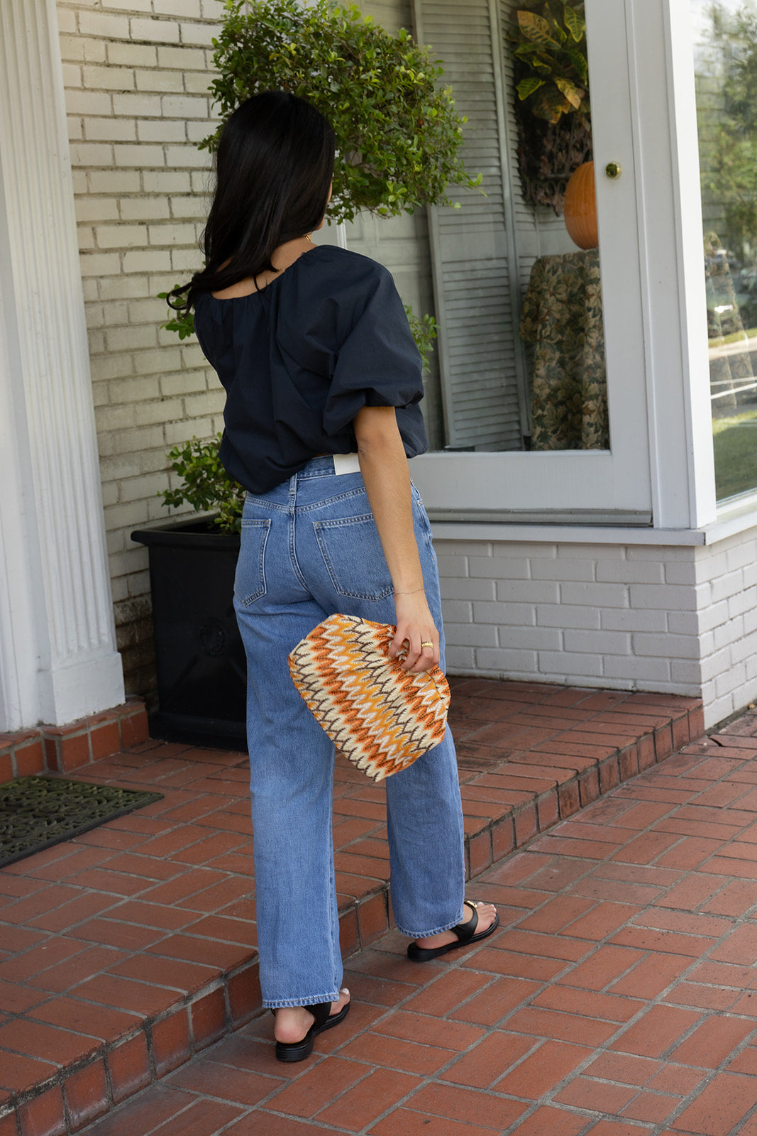 Woman wearing the Cordelia Bubble Hem Top, a navy cropped puff sleeve top with a tie front