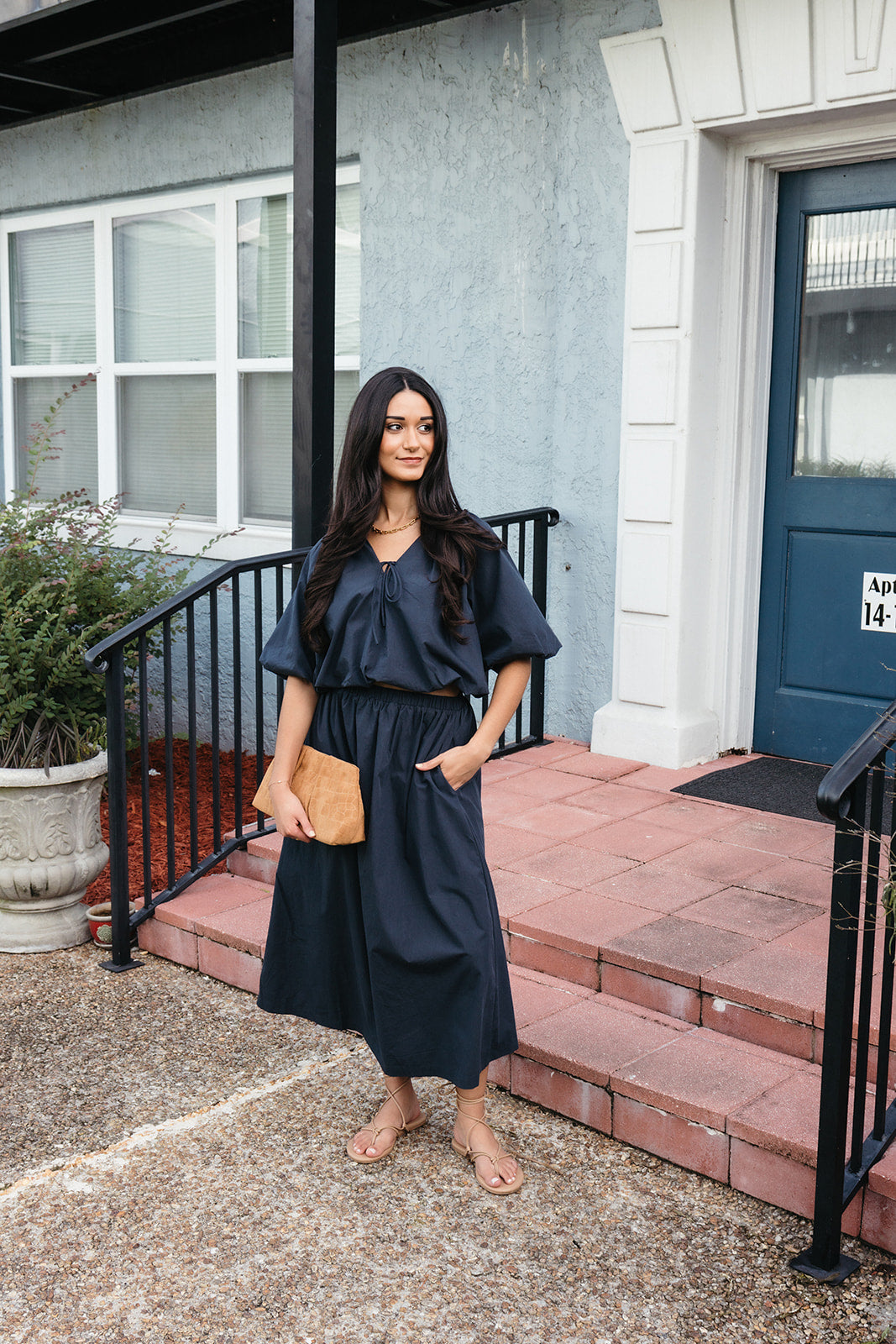 Woman wearing the Cordelia Skirt, a navy maxi skirt with an elastic waist and pockets
