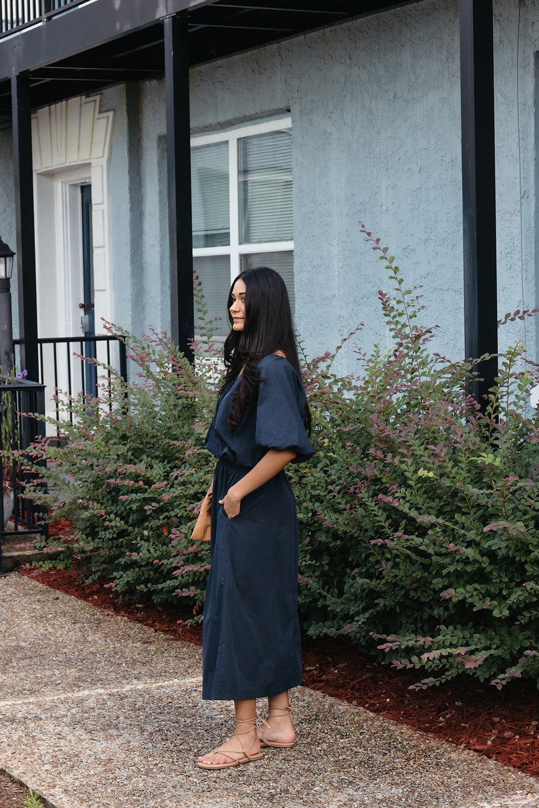 Woman wearing the Cordelia Bubble Hem Top, a navy cropped puff sleeve top with a tie front