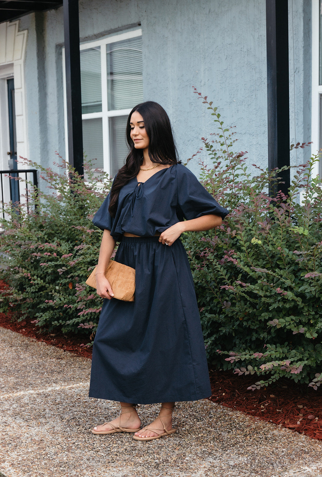 Woman wearing the Cordelia Bubble Hem Top, a navy cropped puff sleeve top with a tie front