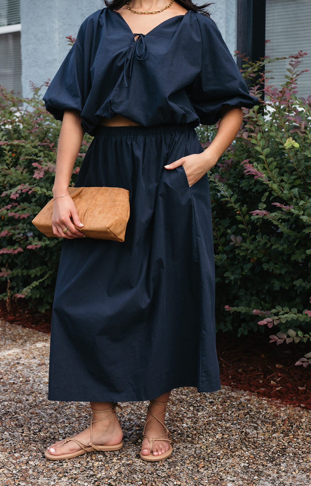 Woman wearing the Cordelia Bubble Hem Top, a navy cropped puff sleeve top with a tie front