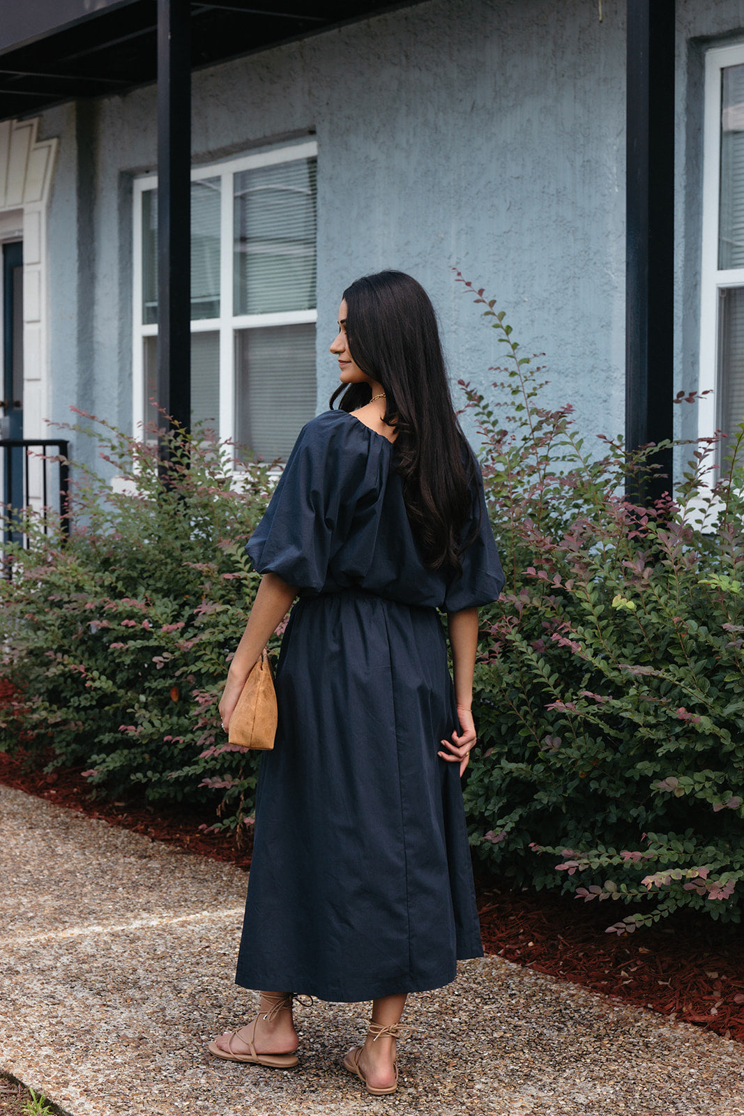 Woman wearing the Cordelia Skirt, a navy maxi skirt with an elastic waist and pockets