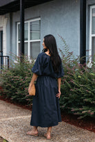 Woman wearing the Cordelia Skirt, a navy maxi skirt with an elastic waist and pockets