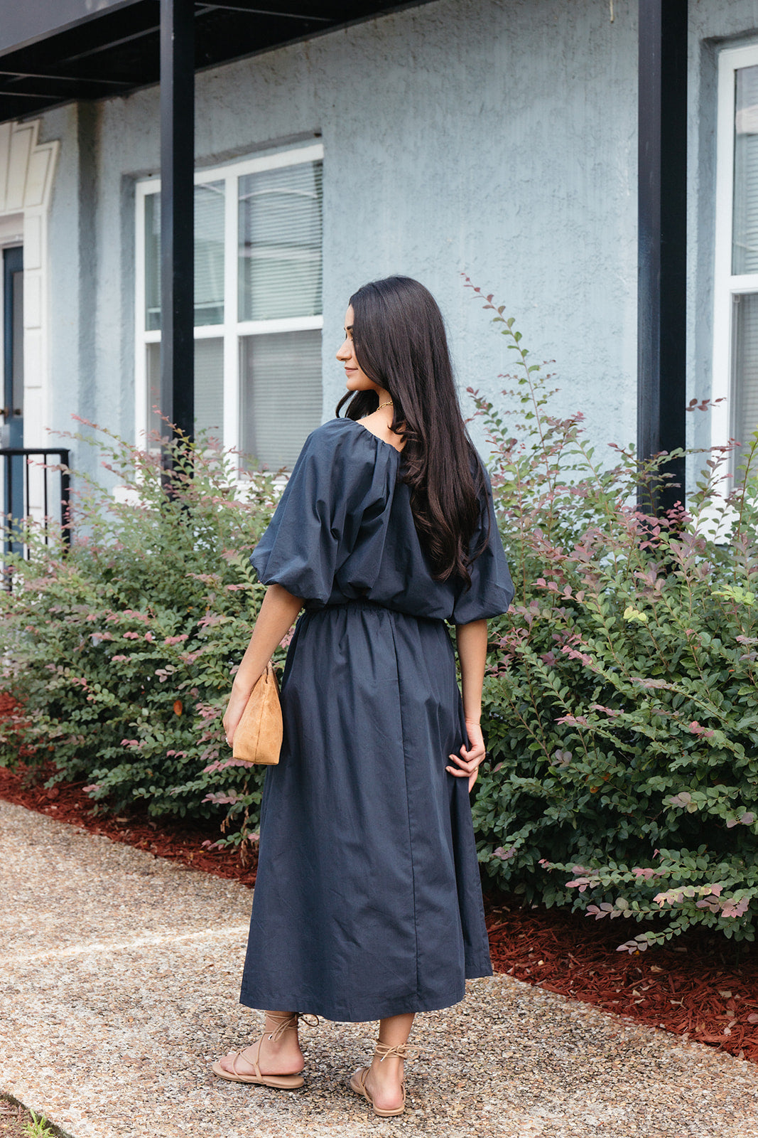Woman wearing the Cordelia Bubble Hem Top, a navy cropped puff sleeve top with a tie front
