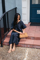 Woman wearing the Cordelia Skirt, a navy maxi skirt with an elastic waist and pockets