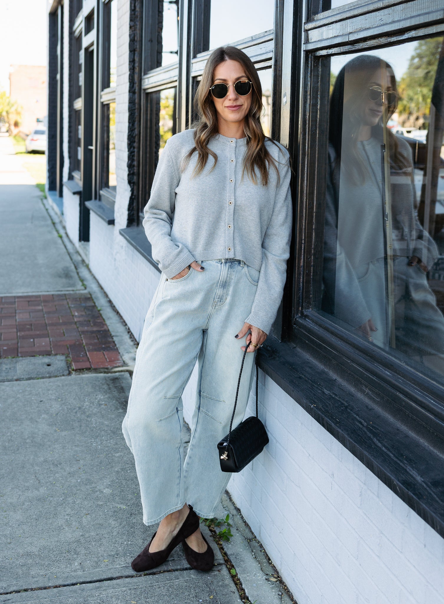 Woman wearing the Cova Cardigan, a grey cropped cotton-wool crewneck cardigan