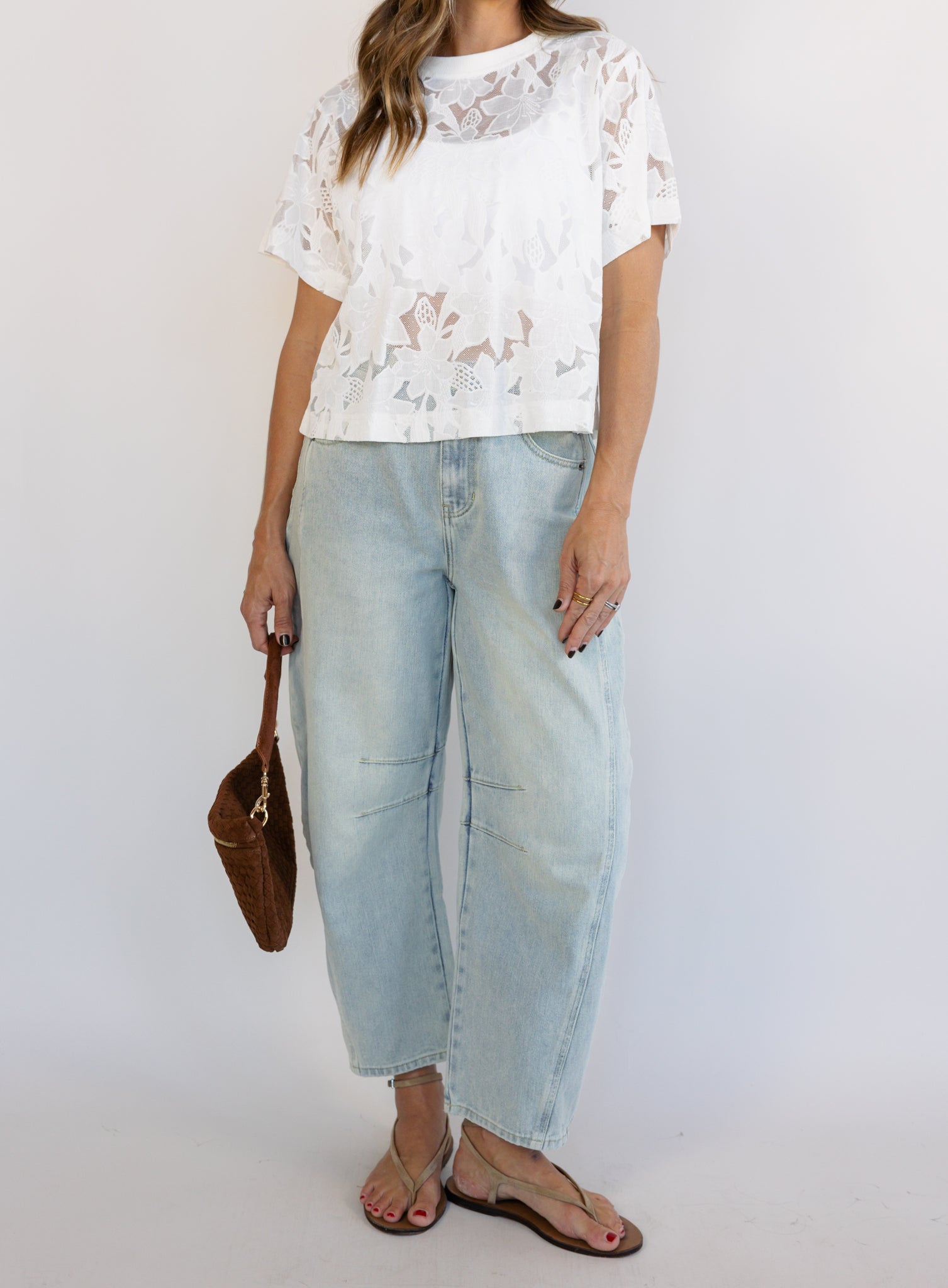 Woman wearing the Lillia Lace Floral Tee, a sheer white mesh tee with floral embroidery