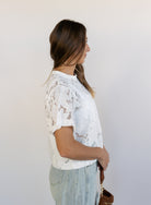 Woman wearing the Lillia Lace Floral Tee, a sheer white mesh tee with floral embroidery