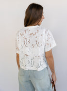 Woman wearing the Lillia Lace Floral Tee, a sheer white mesh tee with floral embroidery