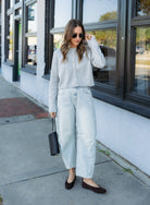 Woman wearing the Cova Cardigan, a grey cropped cotton-wool crewneck cardigan