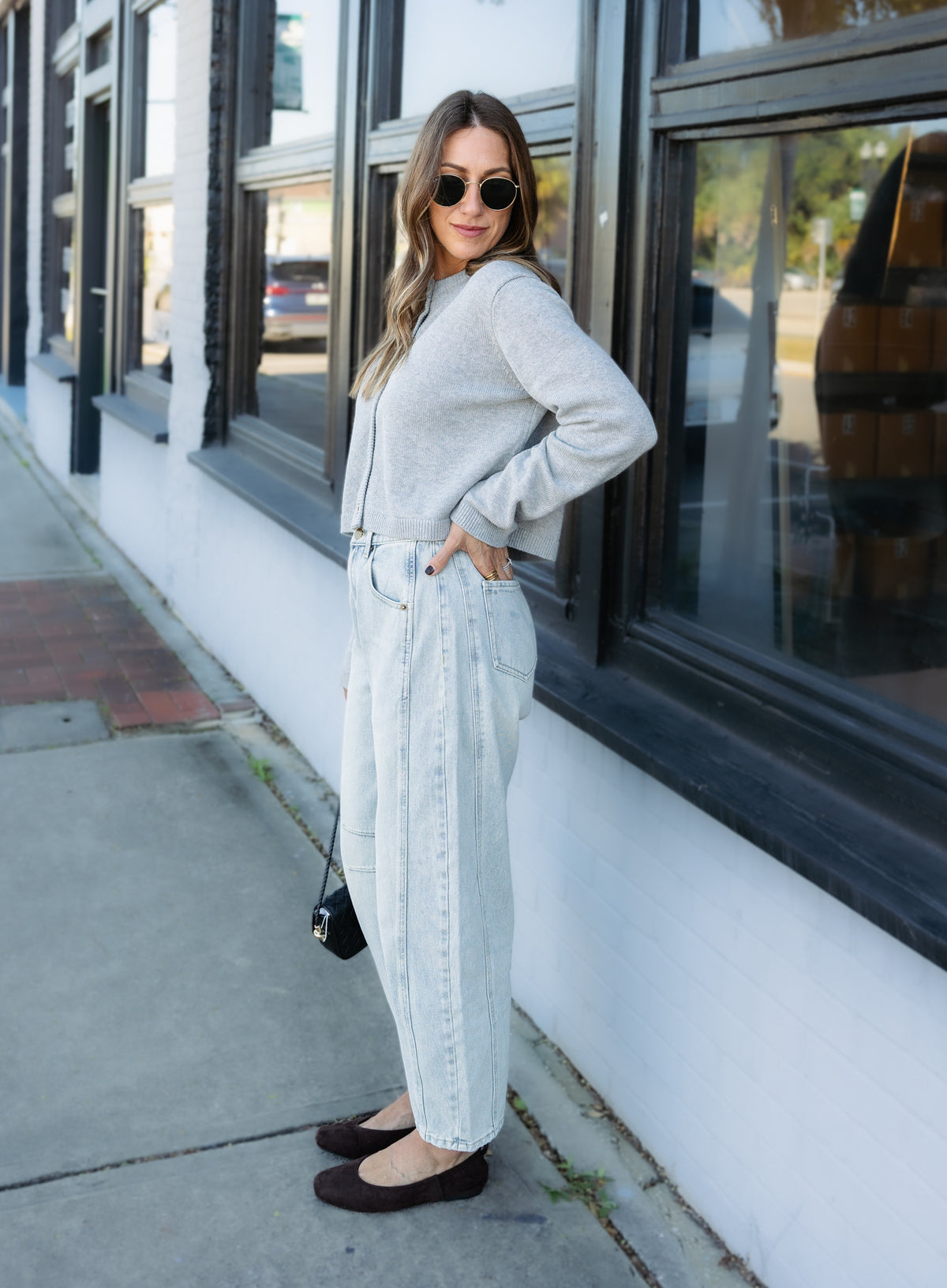 Woman wearing the Cova Cardigan, a grey cropped cotton-wool crewneck cardigan