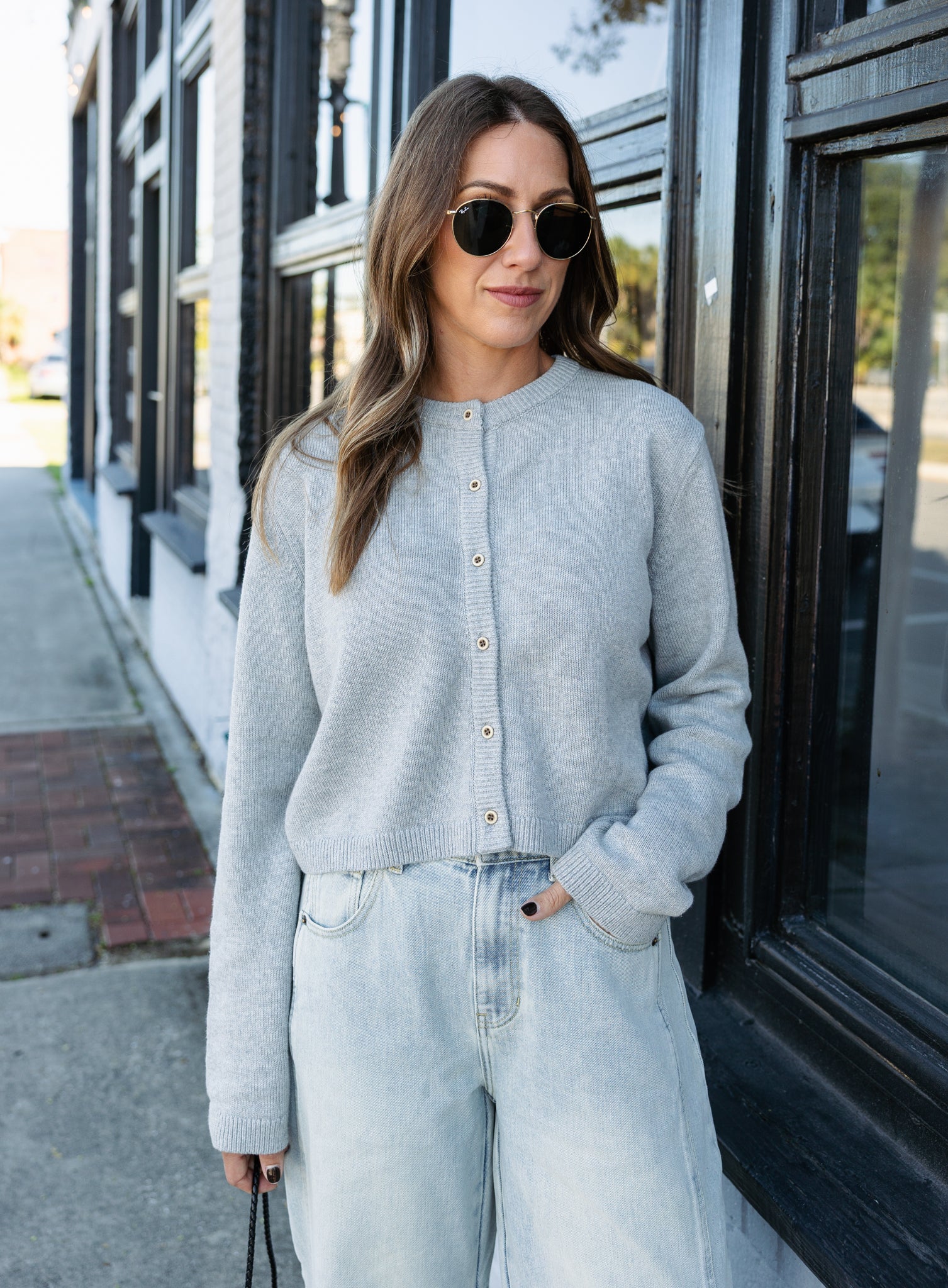 Woman wearing the Cova Cardigan, a grey cropped cotton-wool crewneck cardigan