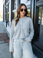 Woman wearing the Cova Cardigan, a grey cropped cotton-wool crewneck cardigan