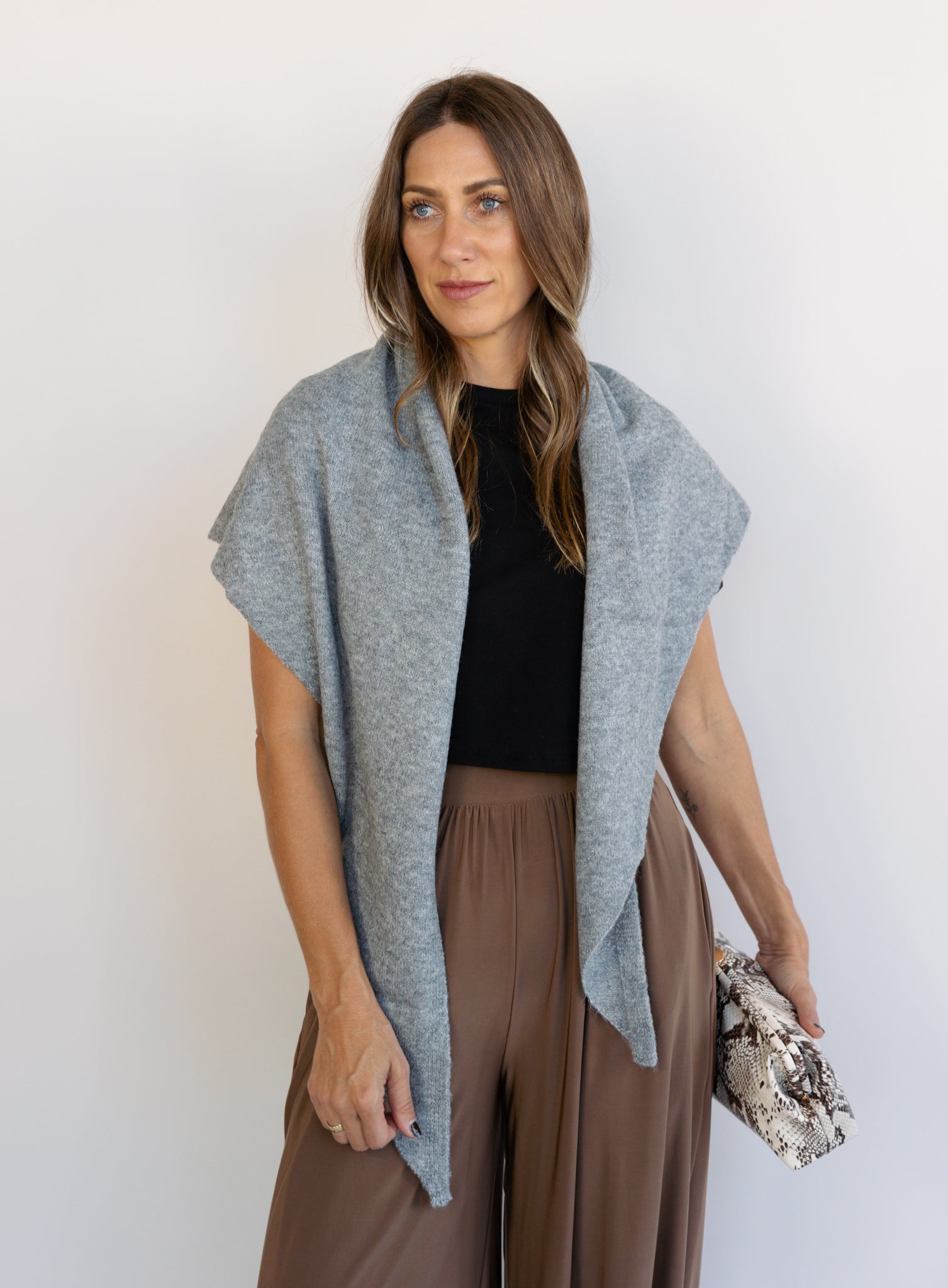 Woman wearing the Wrenley Warm Shawl Scarf in Grey, a heathered grey knit triangle shawl