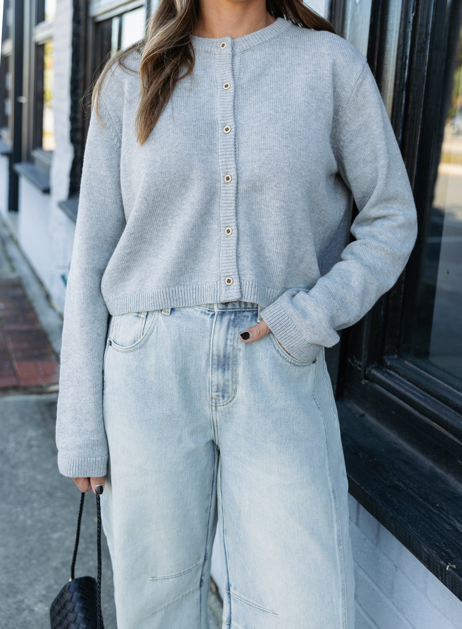 Woman wearing the Cova Cardigan, a grey cropped cotton-wool crewneck cardigan