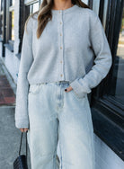 Woman wearing the Cova Cardigan, a grey cropped cotton-wool crewneck cardigan