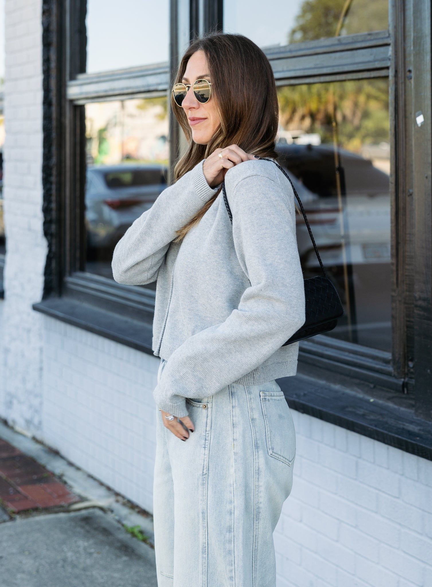 Woman wearing the Cova Cardigan, a grey cropped cotton-wool crewneck cardigan