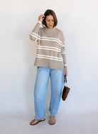 Woman wearing the Lucille Sweater in Taupe, an oversized taupe and cream striped crewneck sweater
